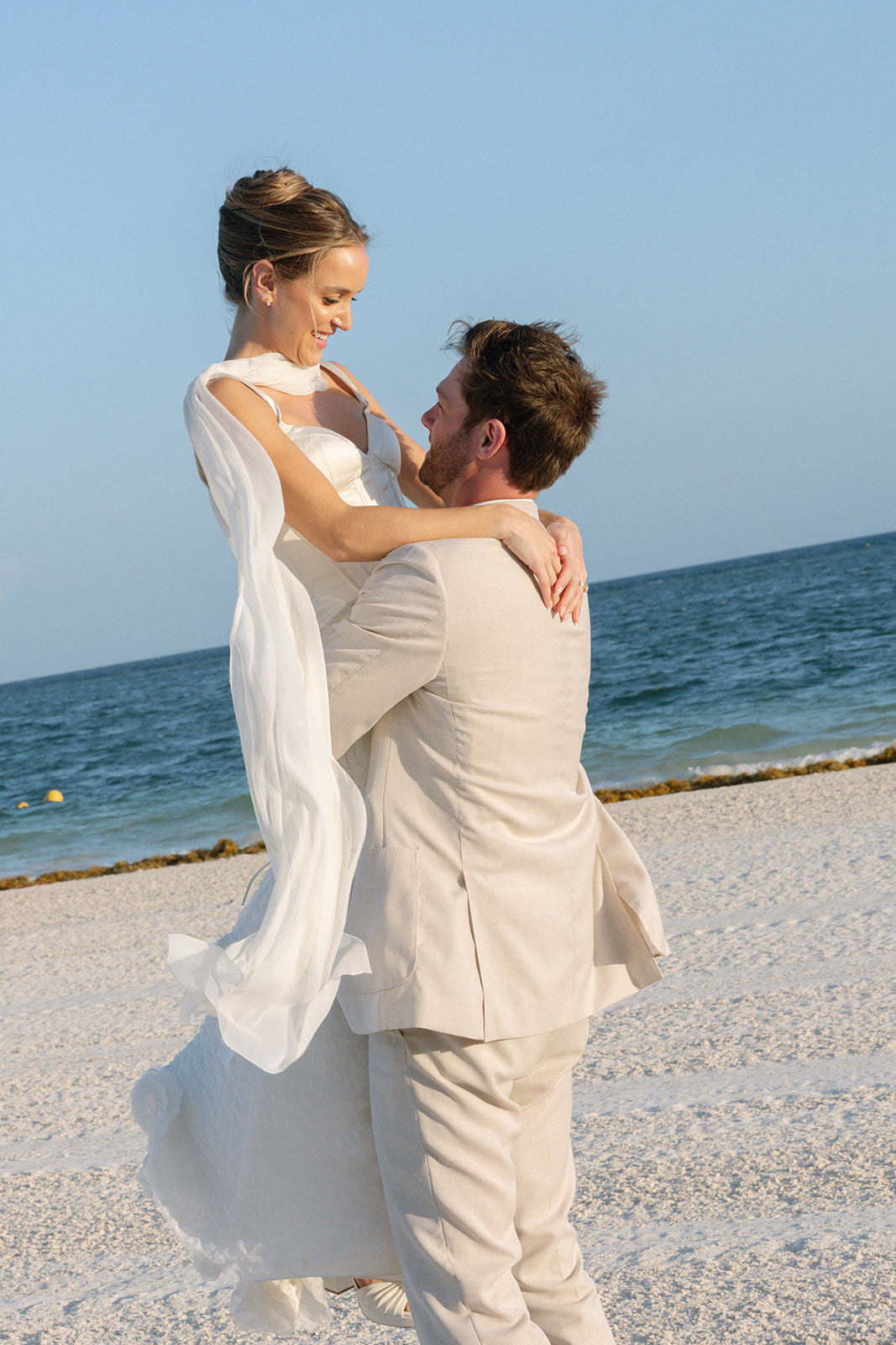 Maddie & Steven — the couple on the beach at Chablé Maroma, the groom lifting the bride