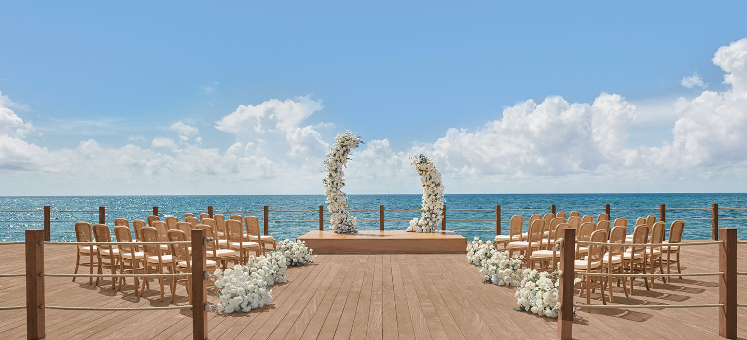 Oceanfront wedding ceremony with floral arch overlooking the Caribbean