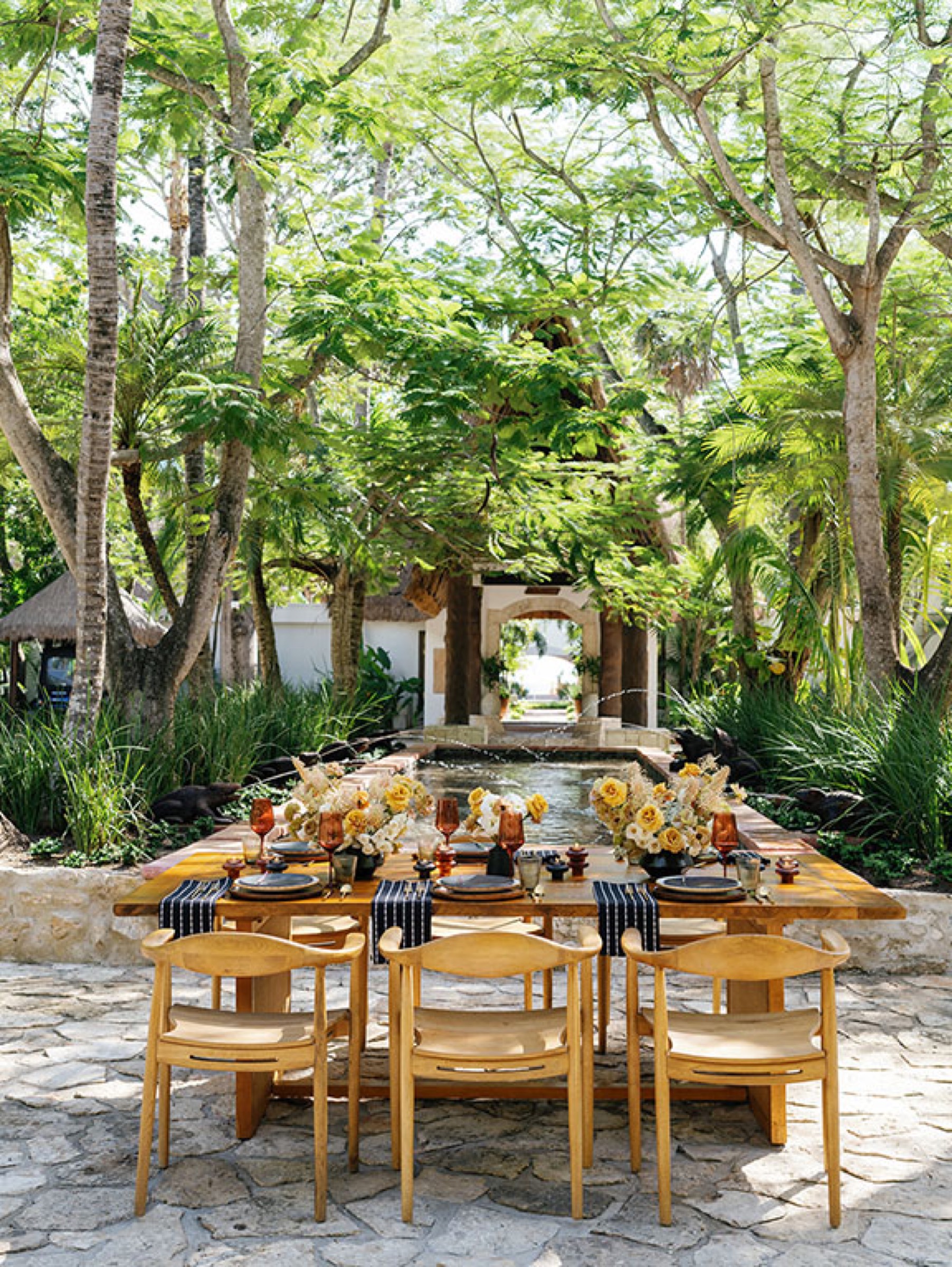 Curated jungle reception with wood table, chairs and yellow florals
